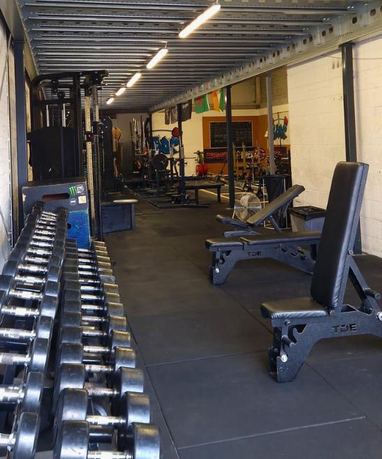 Dumbbells from 2.5 to 60kg racked under the mezzanine